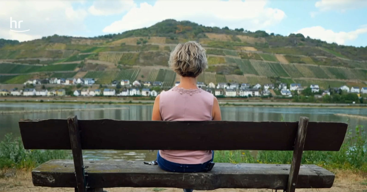 Blick nach Hessen: Bärbel Weinert am Bacharacher Rheinufer. Screenshot: Hessischer Rundfunk
